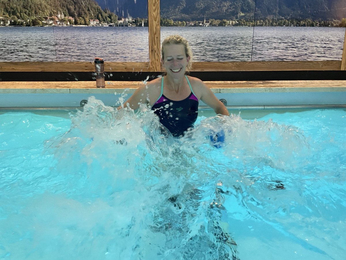 Lächelnde Teilnehmerin beim Training mit Aqua-Hanteln im Wasser